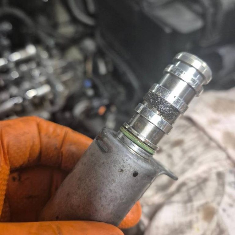 GJ Motors mechanic holding blocked VVT solenoid valve filters from a 2016 Peugeot 208 1.2 PureTech to show rubber debris contamination